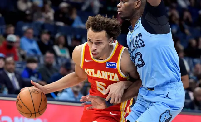 Atlanta Hawks guard Dyson Daniels (5) handles the ball against Memphis Grizzlies forward Cedric Coward (23) in the first half of an NBA basketball game Wednesday, Jan. 21, 2026, in Memphis, Tenn. (AP Photo/Brandon Dill)