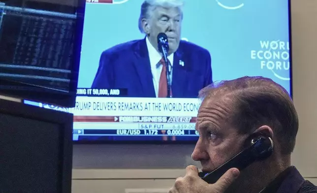 Trader Michale Smyth works on the floor of the New York Stock Exchange as President Donald Trump speaks at the World Economic Forum, Wednesday, Jan. 21, 2026. (AP Photo/Richard Drew)
