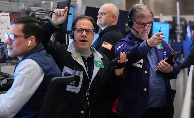 Options traders Anthony Spina, second left, and Brian Garvey, right, work on the floor of the New York Stock Exchange, Wednesday, Jan. 21, 2026. (AP Photo/Richard Drew)