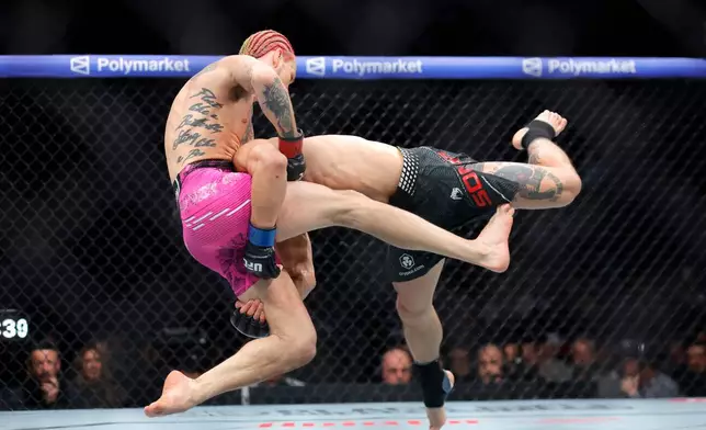 Sean O'Malley, left, is taken down by Song Yadong, right, in a bantamweight bout during the UFC 324 mixed martial arts event Saturday, Jan. 24, 2026, in Las Vegas. (AP Photo/Steve Marcus)