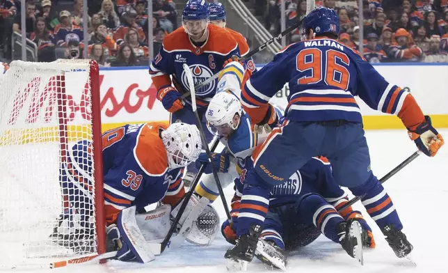 St. Louis Blues' Nathan Walker (26) is stopped by Edmonton Oilers' goalie Connor Ingram (39) during the third period of an NHL hockey game in Edmonton, Alberta, Sunday, Jan. 18, 2026. (Jason Franson/The Canadian Press via AP)