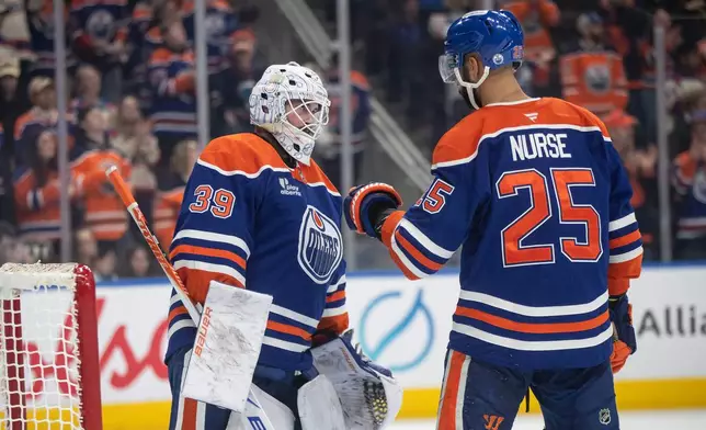 Edmonton Oilers' goalie Connor Ingram (39) and Darnell Nurse (25) celebrate the win over the St. Louis Blues during third period NHL hockey action, in Edmonton on Sunday, Jan. 18, 2026. (Jason Franson/The Canadian Press via AP)