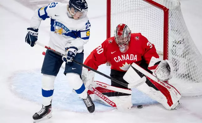Finland scores on Canada goaltender Carter George (30) while Finland's Jasper Kuhta (29) stands in front of the net, during the first period of an IIHF World Junior Hockey Championship bronze medal game in St. Paul, Minn., Monday, Jan. 5, 2026. (Christopher Katsarov/The Canadian Press via AP)