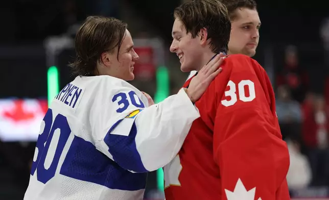 Finland goalie Petteri Rimpinen, left, greets Canada goalie Carter George after an IIHF World Junior Hockey Championship bronze medal game, Monday, Jan. 5, 2026, in St. Paul, Minn. (AP Photo/Matt Krohn)