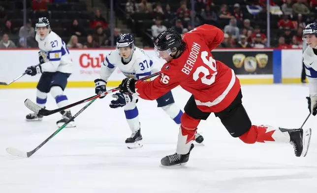 Canada forward Cole Beaudoin (26) shoots against Finland forward Matias Vanhanen (37) during the second period of an IIHF World Junior Hockey Championship bronze medal game, Monday, Jan. 5, 2026, in St. Paul, Minn. (AP Photo/Matt Krohn)