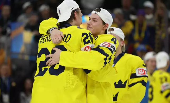 Sweden Jack Berglund (26) and Leo Sahlin Wallenius (4) celebrate after winning an IIHF World Junior Hockey Championship gold medal game against Czechia, Monday, Jan. 5, 2026, in St. Paul, Minn. (AP Photo/Matt Krohn)