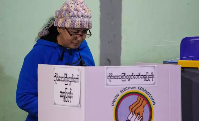 A voter casts her ballot at a polling station during the third phase of general election in Mandalay, central Myanmar, Sunday, Jan. 25, 2026. (AP Photo/Aung Shine Oo)