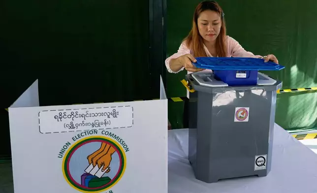 A official of the Union Election Commission prepares a voting booth at a polling station, one day ahead of the third phase of the general election, in Yangon, Myanmar, Saturday, Jan. 24, 2026. (AP Photo/Thein Zaw)