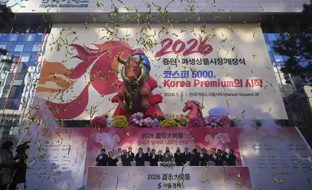 South Korean financial officers celebrate the opening for the 2026 trading year outside of the Korea Exchange in Seoul, South Korea, Friday, Jan. 2, 2026. (AP Photo/Lee Jin-man)