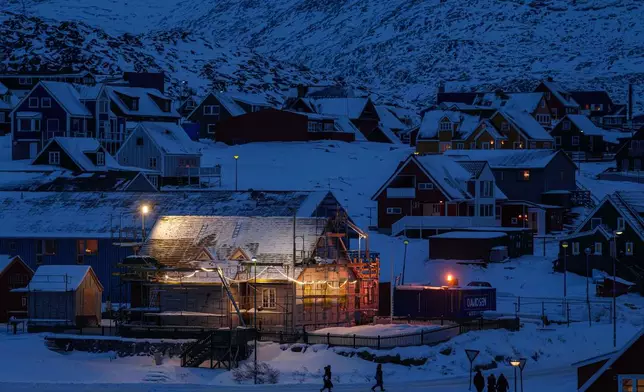 People walk along a street in downtown of Nuuk, Greenland, on Tuesday, Jan. 13, 2026. (AP Photo/Evgeniy Maloletka)