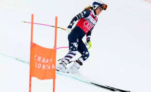 United States' Lindsey Vonn grimaces as she approaches the finish area after crashing, during an alpine ski, women’s World Cup downhill, in Crans Montana, Switzerland, Friday, Jan. 30, 2026. (Jean-Christophe Bott/Keystone via AP)