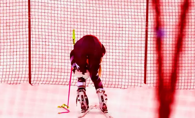 United States' Lindsey Vonn holds her left knee after crashing, during an alpine ski, women's World Cup downhill, in Crans Montana, Switzerland, Friday, Jan. 30, 2026. (Jean-Christophe Bott/Keystone via AP)