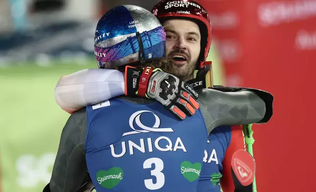 Switzerland's Loic Meillard celebrates with second placed Brazil's Lucas Pinheiro Braathen, back to camera, after winning an alpine ski, men's World Cup giant slalom in Schladming, Austria, Tuesday, Jan. 27, 2026. (AP Photo/Gabriele Facciotti)