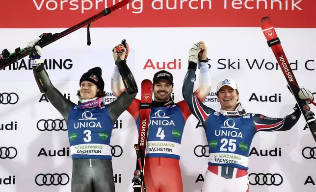 Switzerland's Loic Meillard, centre, winner of alpine ski, men's World Cup giant slalom, poses with second placed Brazil's Lucas Pinheiro Braathen, left, and third placed France's Alban Elezi Cannaferina, in Schladming, Austria, Tuesday, Jan. 27, 2026. (AP Photo/Gabriele Facciotti)