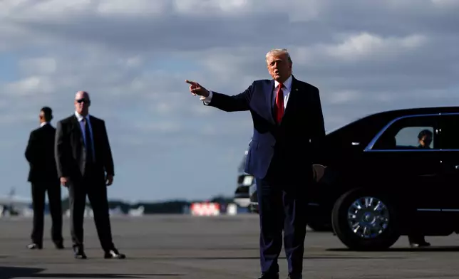 President Donald Trump points after arriving at Palm Beach International Airport on Air Force One, Friday, Jan. 16, 2026, in West Palm Beach, Fla. (AP Photo/Julia Demaree Nikhinson)