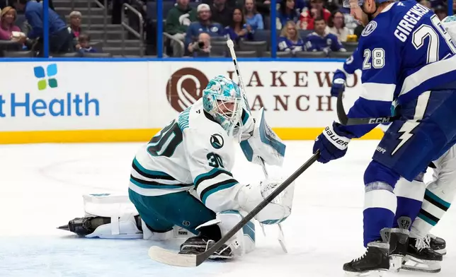 San Jose Sharks goaltender Yaroslav Askarov (30) makes a save on a shot by Tampa Bay Lightning center Zemgus Girgensons (28) during the second period of an NHL hockey game Tuesday, Jan. 20, 2026, in Tampa, Fla. (AP Photo/Chris O'Meara)