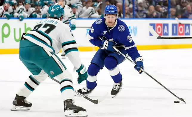 Tampa Bay Lightning left wing Brandon Hagel (38) works around San Jose Sharks defenseman Timothy Liljegren (37) during the second period of an NHL hockey game Tuesday, Jan. 20, 2026, in Tampa, Fla. (AP Photo/Chris O'Meara)