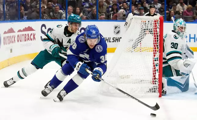 Tampa Bay Lightning left wing Brandon Hagel (38) beats San Jose Sharks center Alexander Wennberg (21) to the puck during the second period of an NHL hockey game Tuesday, Jan. 20, 2026, in Tampa, Fla. (AP Photo/Chris O'Meara)