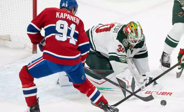 Minnesota Wild goaltender Jesper Wallstedt (30) makes a save against Montreal Canadiens' Oliver Kapanen (91) during the first period of an NHL hockey game in Montreal, Tuesday, Jan. 20, 2026. (Christinne Muschi/The Canadian Press via AP)