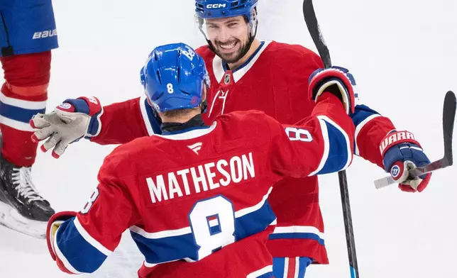 Montreal Canadiens' Alexandre Carrier (45) celebrates his goal over the Minnesota Wild with teammate Mike Matheson (8) during the first period of an NHL hockey game in Montreal, Tuesday, Jan. 20, 2026. (Christinne Muschi/The Canadian Press via AP)