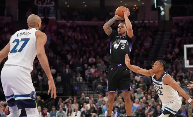 Utah Jazz guard Keyonte George (3) shoots as Minnesota Timberwolves guard Jaylen Clark (22) and center Rudy Gobert (27) defend during the first half of an NBA basketball game Tuesday, Jan. 20, 2026, in Salt Lake City. (AP Photo/Bethany Baker)