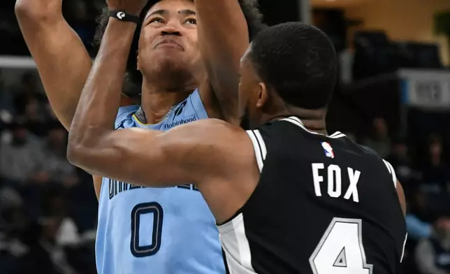 Memphis Grizzlies forward Jaylen Wells (0) shoots against San Antonio Spurs guard De'aaron Fox (4) in the first half of an NBA basketball game Tuesday, Jan. 6, 2026, in Memphis, Tenn. (AP Photo/Brandon Dill)