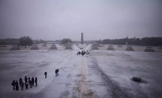 Visitors take a tour though the Nazi Concentration Camp Sachsenhausen on the eve on the International Holocaust Memorial Day in Oranienburg, Germany, Monday, Jan. 26, 2026. (AP Photo/Markus Schreiber)