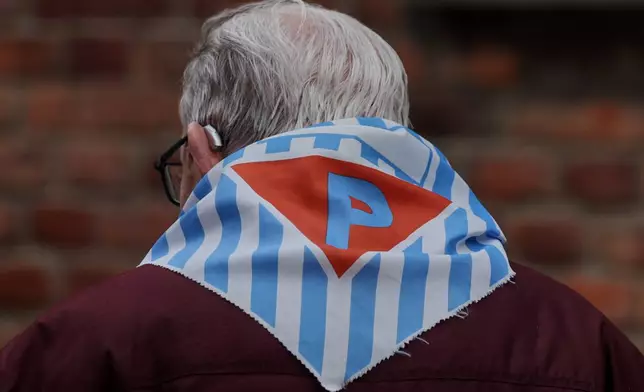 A Holocaust survivor walks in the Auschwitz Nazi death camp museum during a ceremony marking the 81th anniversary of the camp's liberation in Oswiecim, Poland, Tuesday, Jan. 27, 2026. (AP Photo/Beata Zawrzel)