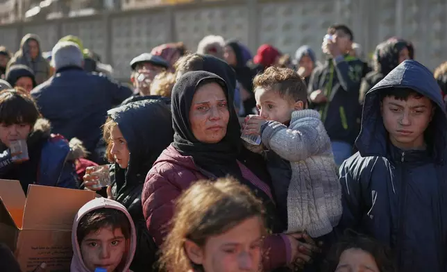 Civilians evacuate an area of the Sheikh Maqsoud neighborhood, where clashes between government forces and Kurdish fighters have been taking place in the northern city of Aleppo, Syria, Saturday, Jan. 10, 2026. (AP Photo/Ghaith Alsayed)