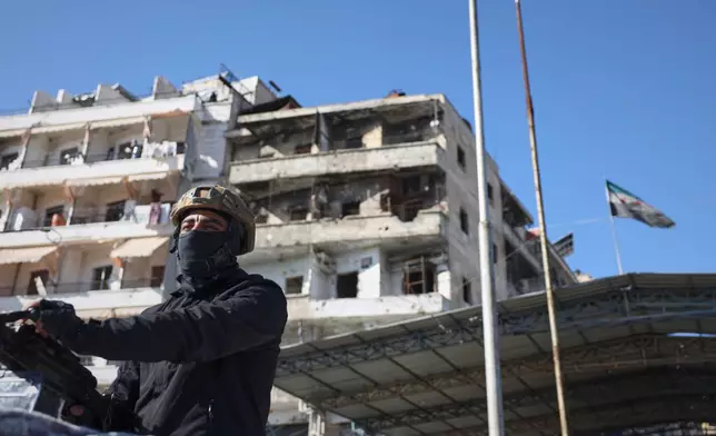 A Syrian police convoy secures the area just outside the Sheikh Maqsoud neighborhood, where clashes between government forces and Kurdish fighters have been taking place in the northern city of Aleppo, Syria, Saturday, Jan. 10, 2026. (AP Photo/Omar Albam)