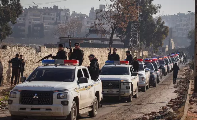 A Syrian police convoy gathers in the Sheikh Maqsoud neighborhood, where clashes between government forces and Kurdish fighters have been taking place in the northern city of Aleppo, Syria, Saturday, Jan. 10, 2026. (AP Photo/Omar Albam)