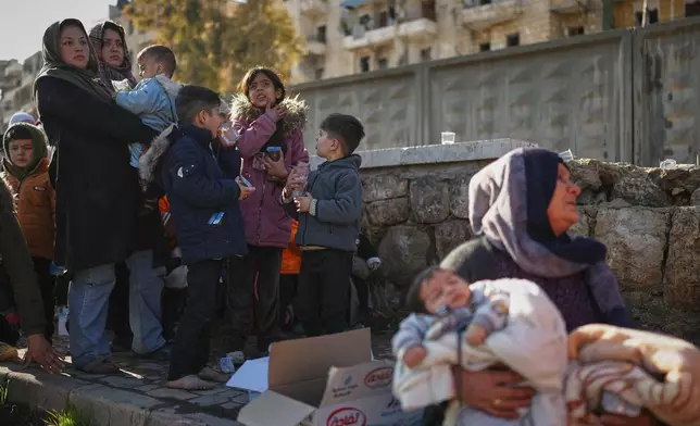 Civilians evacuate an area of the Sheikh Maqsoud neighborhood, where clashes between government forces and Kurdish fighters have been taking place in the northern city of Aleppo, Syria, Saturday, Jan. 10, 2026. (AP Photo/Ghaith Alsayed)