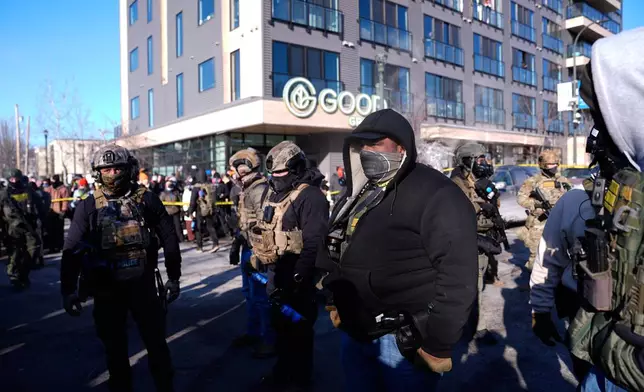 Federal agents stand near the site of a shooting Saturday, Jan. 24, 2026, in Minneapolis. (AP Photo/Abbie Parr)