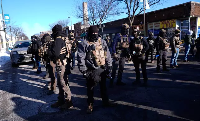 Federal agents stand near the site of a shooting Saturday, Jan. 24, 2026, in Minneapolis. (AP Photo/Abbie Parr)
