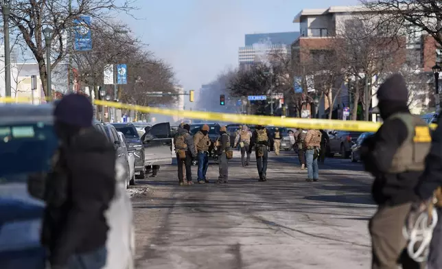 Federal agents stand near the site of a shooting Saturday, Jan. 24, 2026, in Minneapolis. (AP Photo/Abbie Parr)