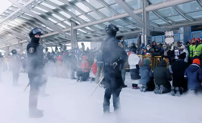 Clergy members and community activists gather at the Minneapolis-St. Paul International Airport, to protest deportation flights and urge airlines to call for an end to the Department of Homeland Security's operation, on Friday, Jan. 23, 2026, in St. Paul, Minn. (Kerem Yücel/Minnesota Public Radio via AP)