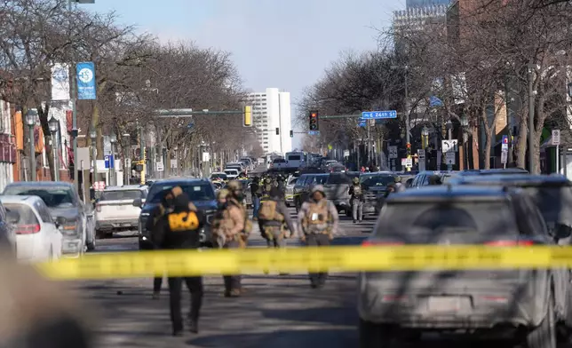 Federal agents stand near the site of a shooting Saturday, Jan. 24, 2026, in Minneapolis. (AP Photo/Abbie Parr)