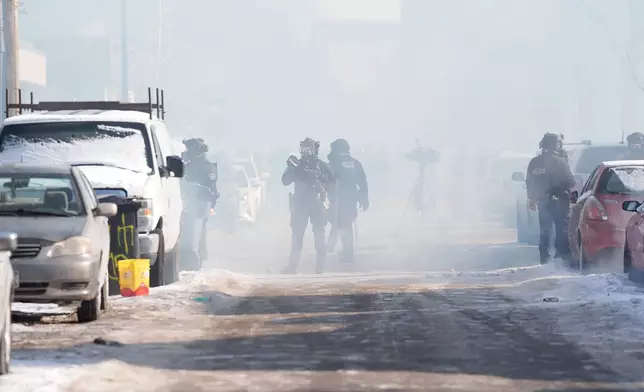 Federal immigration officers deploy tear gas at observers after a shooting Saturday, Jan. 24, 2026, in Minneapolis. (AP Photo/Abbie Parr)