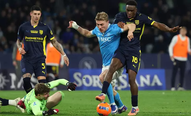 Napoli's Rasmus Hojlund, center, and Parma's Mandela Keita, right, in action during the Serie A soccer match between Napoli and Parma, in Naples, Italy, Wednesday, Jan. 14, 2026. (Alessandro Garofalo/LaPresse via AP)
