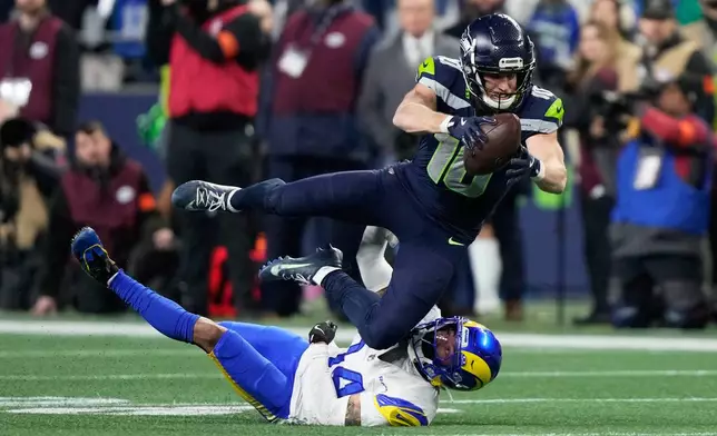 Seattle Seahawks wide receiver Cooper Kupp (10) leaps over Los Angeles Rams cornerback Cobie Durant (14) after a catch during the second half of the NFC Championship NFL football game Sunday, Jan. 25, 2026, in Seattle. (AP Photo/Stephen Brashear)