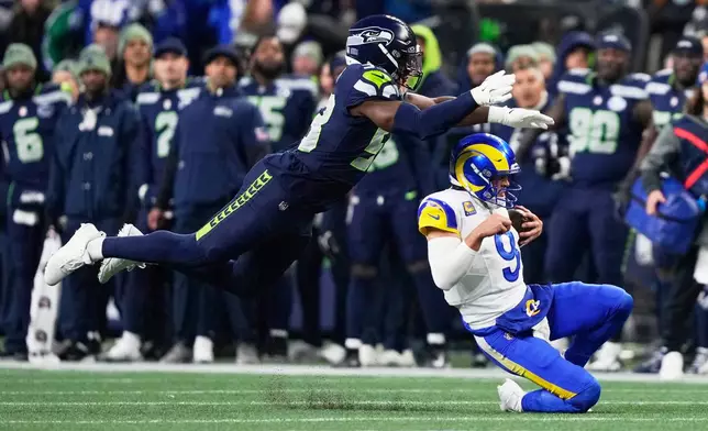 Los Angeles Rams quarterback Matthew Stafford (9) slides under Seattle Seahawks linebacker Boye Mafe (53) during the first half of the NFC Championship NFL football game Sunday, Jan. 25, 2026, in Seattle. (AP Photo/Stephen Brashear)