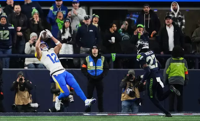 Los Angeles Rams wide receiver Puka Nacua (12) makes a touchdown catch past Seattle Seahawks cornerback Riq Woolen (27) during the second half of the NFC Championship NFL football game Sunday, Jan. 25, 2026, in Seattle. (AP Photo/Lindsey Wasson)