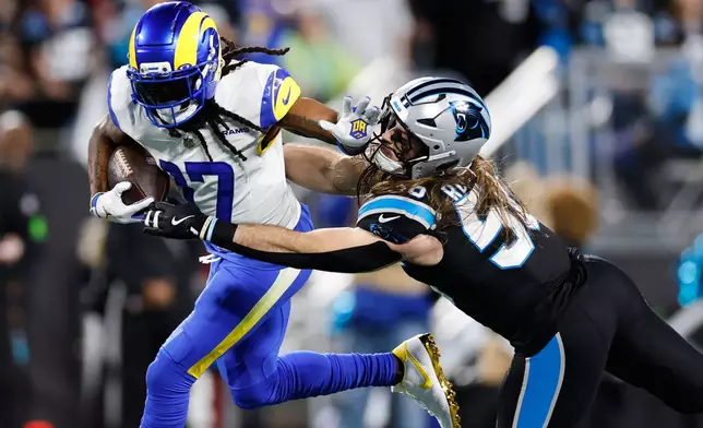 Los Angeles Rams wide receiver Davante Adams (17) is tackled by Carolina Panthers linebacker Christian Rozeboom during the second half of an NFL wild-card playoff football game, Saturday, Jan. 10, 2026, in Charlotte, N.C. (AP Photo/Rusty Jones)