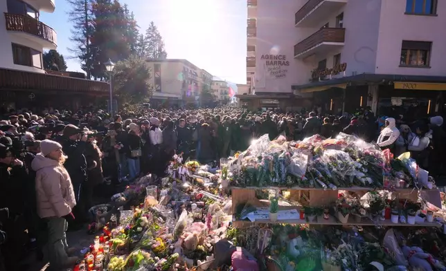 People gather during a memorial procession in Crans-Montana, Swiss Alps, Switzerland, Sunday, Jan. 4, 2026, after a devastating fire in Le Constellation bar left dead and injured during the New Year's celebrations. (AP Photo/ Antonio Calanni)