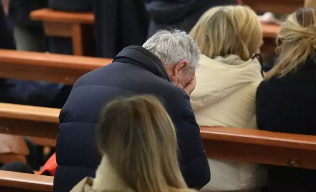 People attend a New Year mass at the catholic church of Montana Station to remember the victims of the devastating fire at the Le Constellation bar, which left dead and injured during the New Year's celebrations in Crans-Montana, Swiss Alps, Switzerland, Thursday, Jan. 1, 2026. (AP Photo/ Antonio Calanni)