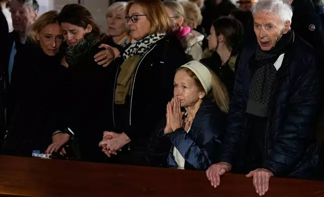 People cry during a memorial mass at the Chapelle St-Christophe in Crans-Montana, Swiss Alps, Switzerland, Sunday, Jan. 4, 2026, after a devastating fire in Le Constellation bar left dead and injured during the New Year's celebrations. (AP Photo/Baz Ratner)