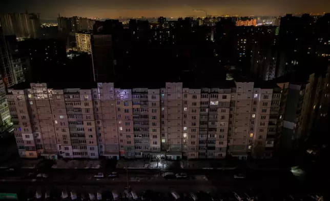 Residential multistory buildings are seen in the dark during large-scale power outages following Russian strikes on Ukraine's power grid in Kyiv, Ukraine, Tuesday, Jan. 20, 2026. (AP Photo/Dan Bashakov)