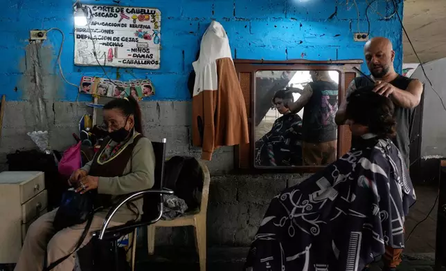 A barber cuts hair at a barbershop in Caracas, Venezuela, Tuesday, Jan. 6, 2026. (AP Photo/Matias Delacroix)