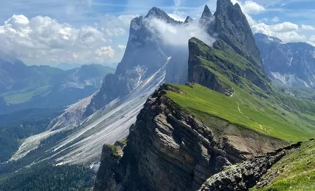 FILE- Clouds hang over the 'Seceda' Dolomites mountain, 2519 meters, near Ortisei val Gardena, (St. Ulrich in Groeden) in northern Italian province of South Tyrol, Italy, June 28, 2021. (AP Photo/Matthias Schrader, File)