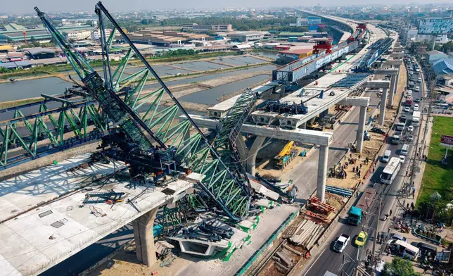 A construction crane that collapsed on the Rama 2 Road elevated expressway in Samut Sakhon province, Thailand on Thursday, Jan. 15, 2026. (AP Photo/Arnun Chonmahatrakool)